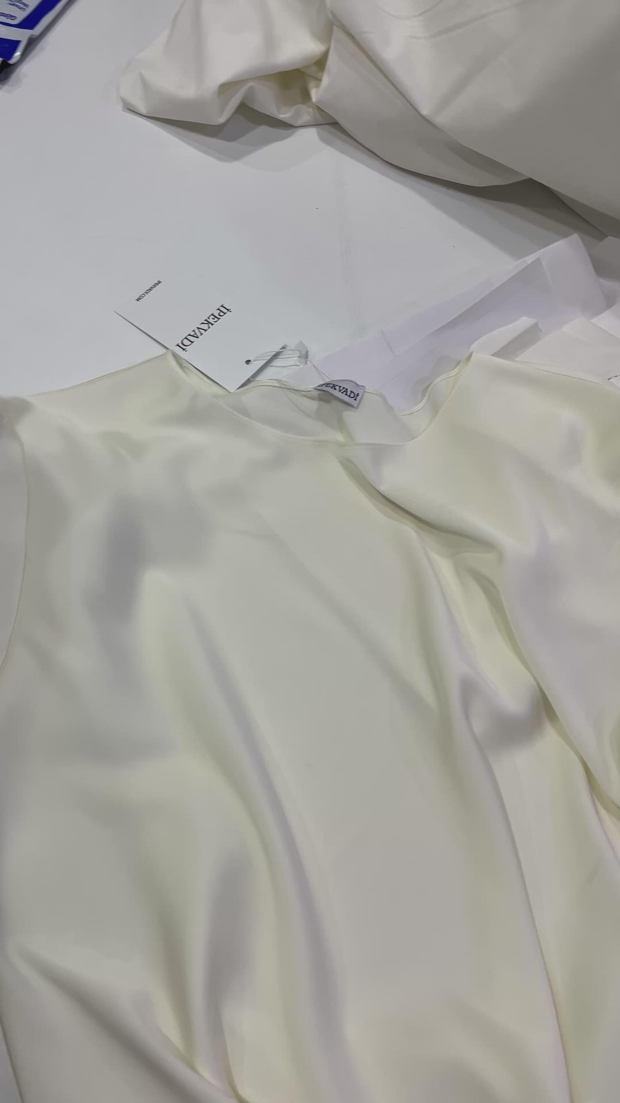 yuvarlak yaka ipek slim fit tişört yakın plan detay, ipekvadi etiketi ve parlak ipek kumaş doku görünümü
